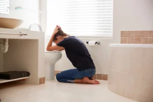 A woman suffering from morning sickness in her bathroom